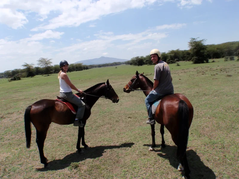 Two riders on horseback on open plains during a safari in Kenya